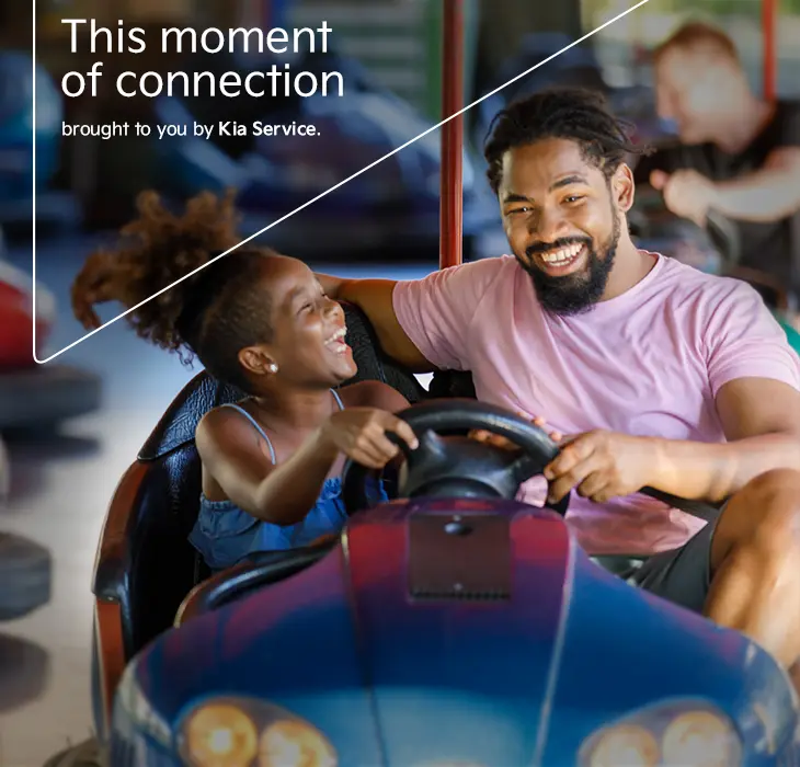 Father and daughter enjoying a bumper car ride.